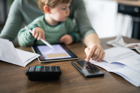 mother calculating budget with son in her lap